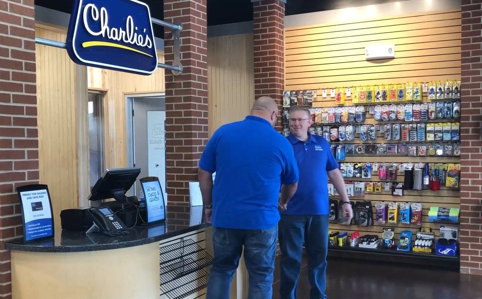 Electrician Cori Young shaking hands with partner Steven Brandt of Charlie's Car Wash