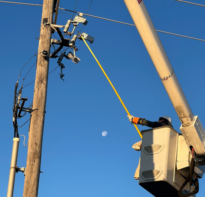 Electrician in bucket working on powerline